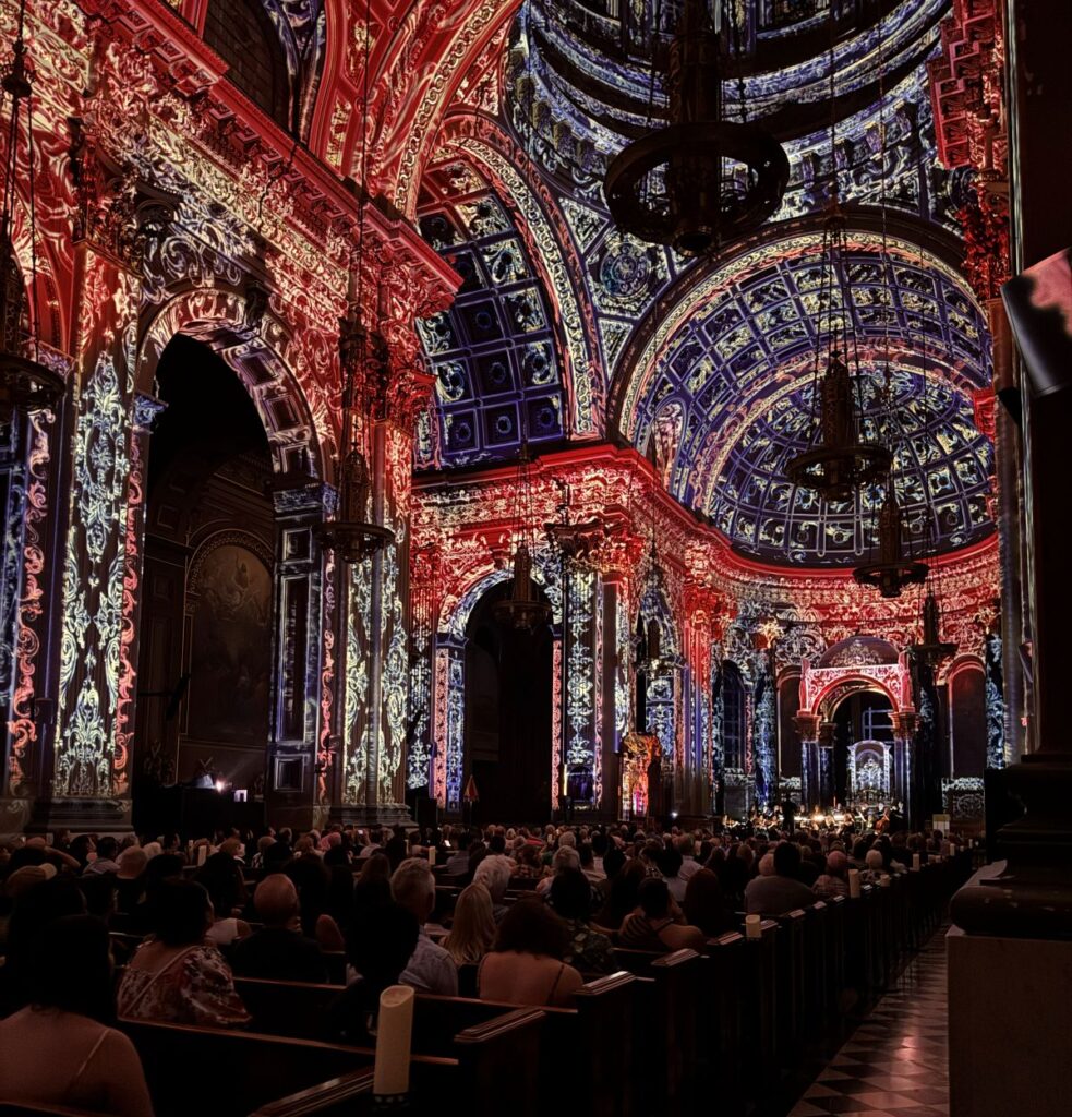 Interior shot of Luminiscence Philadelphia with basilica covered in lights and an audience watching