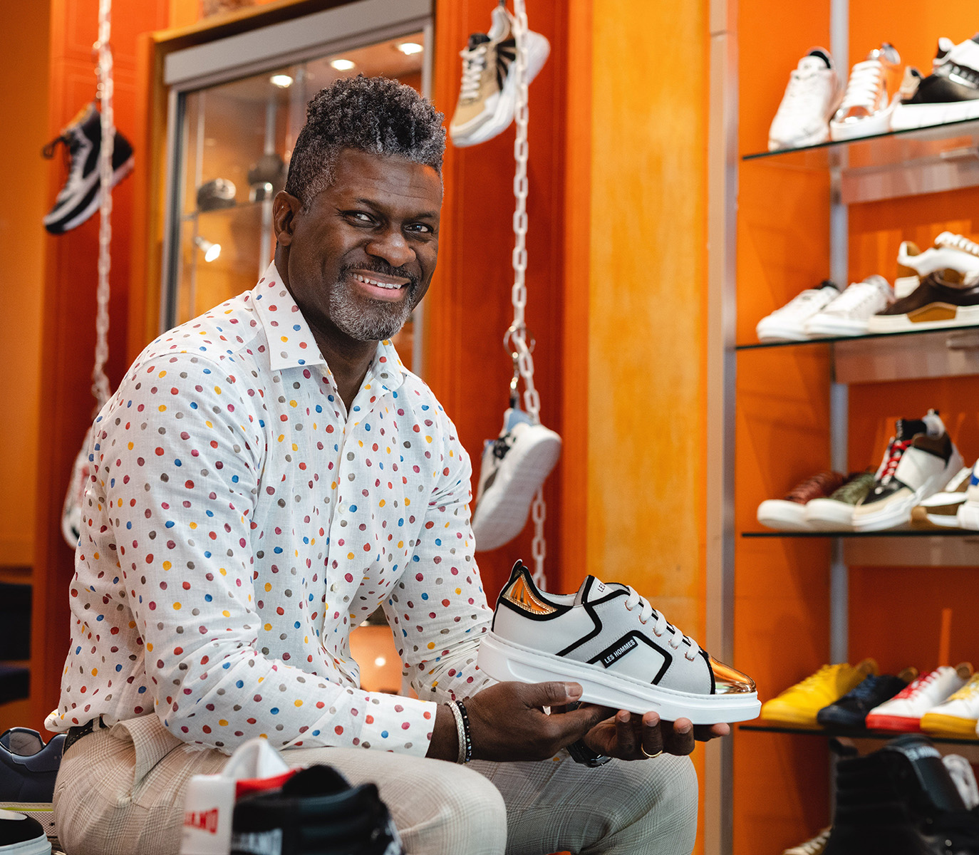 Blue Sole Shoes owner inside his store holding a sneaker.