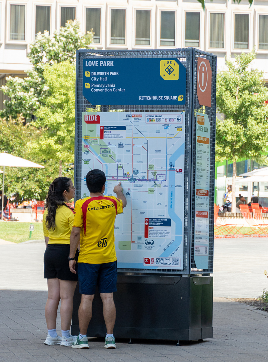 People looking for directions on the wayfinding map at Love Park.