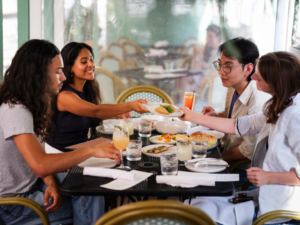 four people sitting at a table at a restaurant over lunch