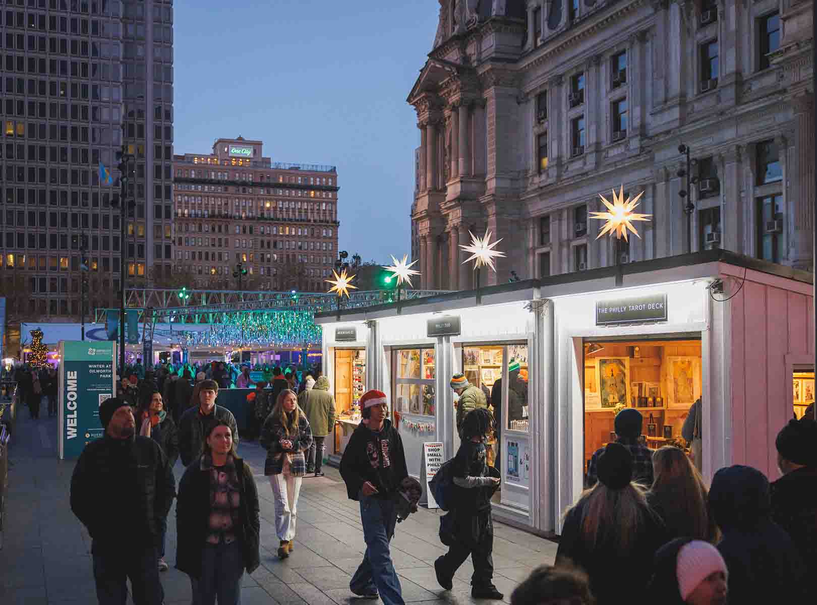 People walking with City Hall and market vendors in the b Winter at Dilworth Park p